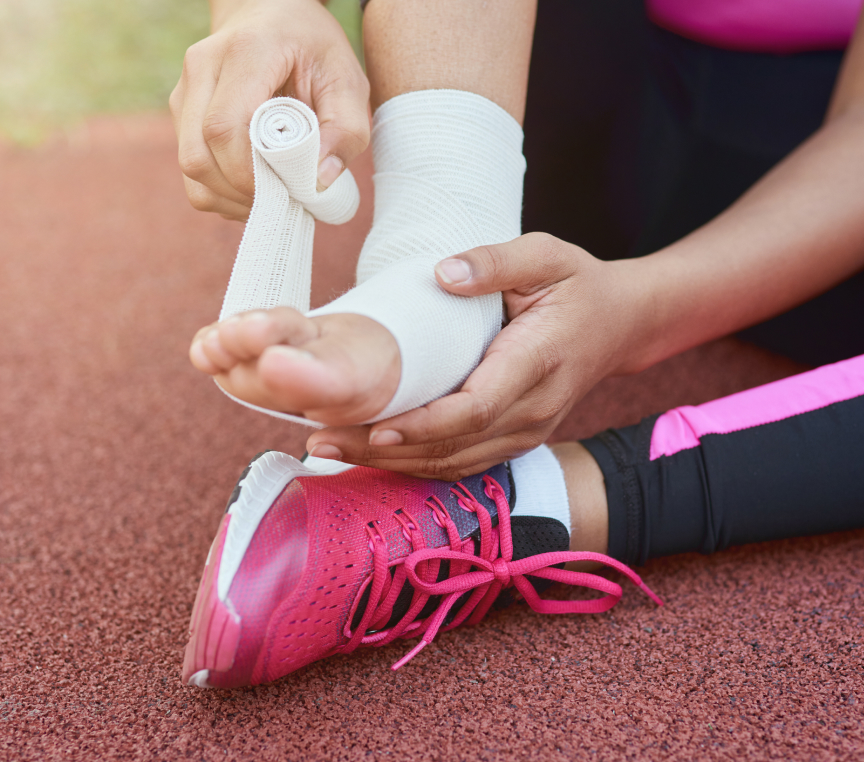 an athlete putting bandage on her foot due to injury on the track